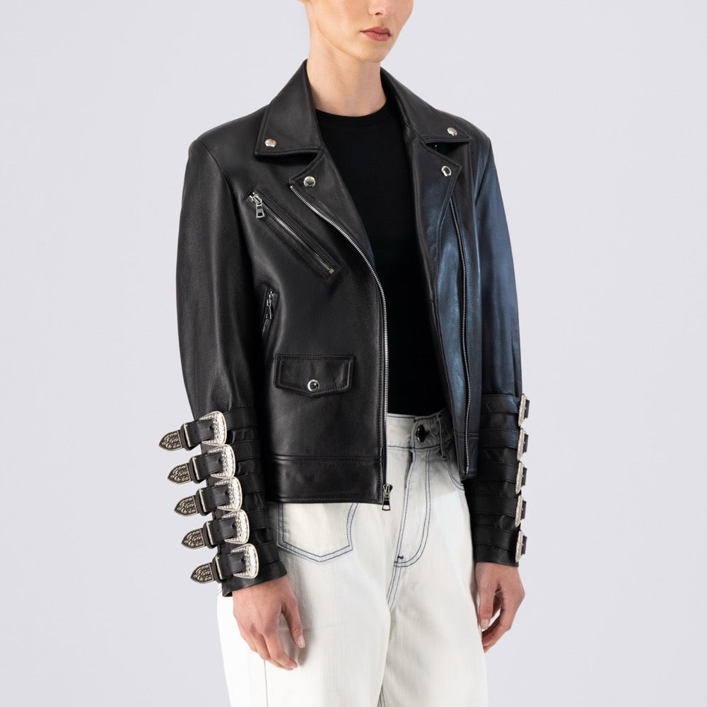 Person wearing a black leather jacket with unique sleeve designs on a light gray background